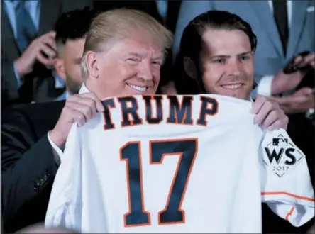  ?? ANDREW HARNIK — THE ASSOCIATED PRESS ?? President Donald Trump poses for photograph­s as Houston Astros’ Josh Reddick, right, presents him with a jersey during a ceremony in the East Room of the White House in Washington, Monday where he honored the World Series Champion Houston Astros for...