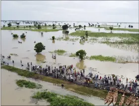  ?? ASSOCIATED PRESS FILE ?? People walk through flooded farmlands after heavy rainfall in Hadeja, Nigeria, Sept. 19.