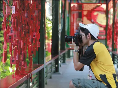  ?? FENG YONGBIN / CHINA DAILY ?? A Malaysian photograph­er at an ancient temple in Tianjin during a cultural exchange.