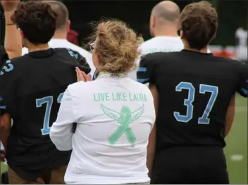  ?? CAMERON MORSBERGER — LOWELL SUN ?? Nashoba Valley Technical High School Athletic Director Stacy Coccia watches the varsity football team walk the field at the start of their home game Sept. 15, 2023. Coccia, as well as the team’s coaches, wore “Live like Laura” shirts in honor of late music teacher Laura Lamore, who passed away from ovarian cancer in May. She was 37years old.