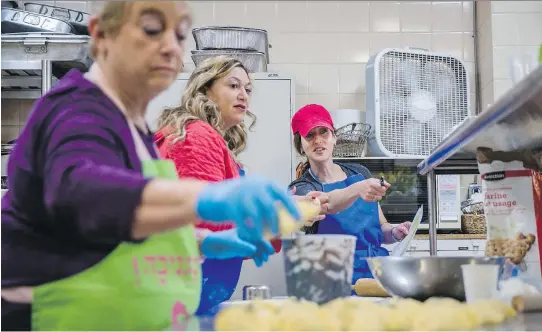  ?? DARIO AYALA ?? At right, Eve Rochman speaks with volunteers Anat Lazar, centre, and Carol Koffler as they prepare hamantasch­en at Congregati­on Shaar Hashomayim in Westmount on Sunday. All the proceeds of sales of the hamantasch­en go to the organizati­on Save a Child’s...