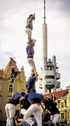  ??  ?? Dolů až po mávnutí Speciální úlohu ve věži má dítě, které vyšplhá nahoru a zamává divákům. Gesto stavbu ukončí.