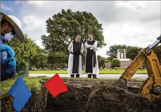  ??  ?? The Revs. Paul McCormick (left) and Joseph Van House of the Cistercian Abbey Our Lady of Dallas watch workers last month as they exhume the graves of the Revs. Rudolph Zimyani and Damian Szodenyi at Calvary Hill Cemetery in Dallas. Twenty deceased...