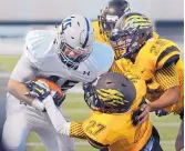  ?? JIM THOMPSON/JOURNAL ?? Cibola’s Matheus Mitchell (27) and Raul Avila (25) team to bring down La Cueva’s Josh Woisin during the Bears’ victory.