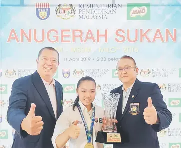  ??  ?? Lee Hui Xian poses with Wushu Federation of Malaysia president Datuk Chong Kim Fatt (right) after receiving her award.