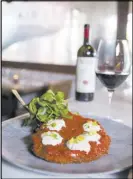 ??  ?? Veal Parmigiana is smothered in sauce, dotted with burrata.