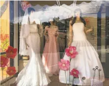  ?? Suman Naishadham / Associated Press ?? Mannequins in wedding gowns are seen in a window at a bridal store in Nogales, Ariz., that has been closed for nearly a year due to the pandemic. Couples are now racing to the altar.