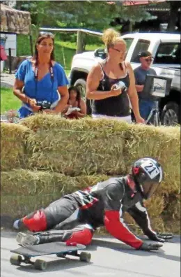  ?? KYLE MENNIG - ONEIDA DAILY DISPATCH ?? Spectators watch a rider hit the hay bales in Crash Corner during Gravity Fest X in Munnsville on Saturday, Aug. 1, 2015.