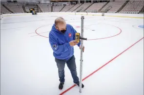  ?? The Canadian Press ?? Icemaker Greg Ewasko checks the ice at the WinSport’s Markin MacPhail Centre where the Scotties Tournament of Hearts will take place, in Calgary, Thursday.