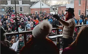  ?? DANA JENSEN/THE DAY ?? Jamie Spillane, right, directs the Mystic Seaport Carolers, foreground, and the crowd gathered on the McGraw Quadrangle during Sunday’s Community Carol Sing at Mystic Seaport.