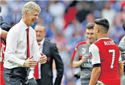  ??  ?? Wembley way: Arsène Wenger and Alexis Sánchez celebrate Arsenal’s record-breaking 13th FA Cup triumph