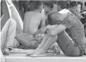  ?? MARCO UGARTE/AP ?? Migrants traveling by foot rest Friday at a sports complex in the town of Mapastepec in Mexico’s Chiapas state. The group hopes to reach the United States.