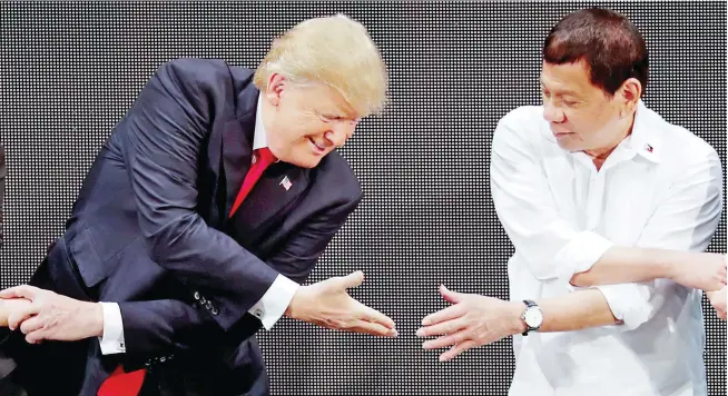  ??  ?? MAKING A CONNECTION – US President Donald Trump tries to link hands with President Duterte during the traditiona­l ‘ASEAN handshake’ at the opening ceremony of the ASEAN Summit in Manila Monday. (Reuters)