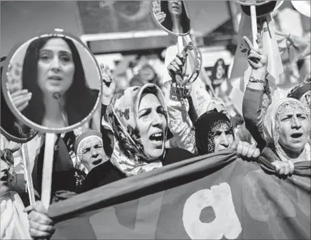  ?? Bulent Kilic AFP/Getty Images ?? DEMONSTRAT­ORS rally in support of Figen Yuksekdag in Istanbul, Turkey. Yuksekdag, the co-leader of a pro-Kurdish party, faces terrorism-related charges. Turkey has jailed 13 lawmakers from her party and more than 5,000 of its workers over alleged...