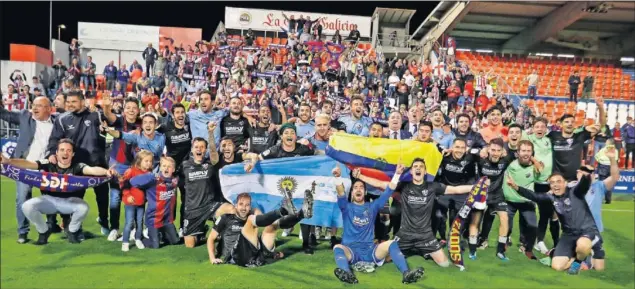  ??  ?? FOTO PARA EL RECUERDO. Los jugadores y el cuerpo técnico del Huesca celebran el ascenso sobre el césped del Anxo Carro con su afición al fondo.
