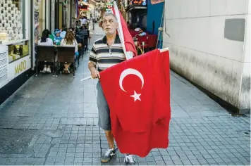  ?? — AFP ?? A man sells Turkish national flags at Istiklal avenue on Thursday in Istanbul. Turkey’s deputy premier said on Thursday the state of emergency declared to fight plotters of last week’s failed coup may only last up to 45 days, despite being declared for...