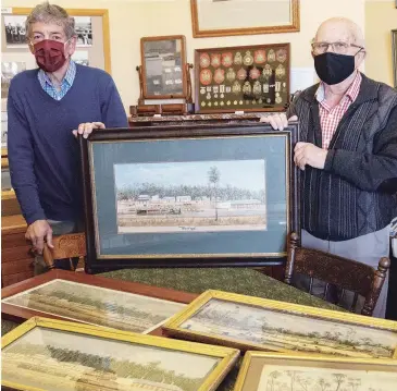  ??  ?? Warragul and District Historical Society members Aldo Bagnara (left) and Malcolm Dickson with the Neville Cayley watercolou­r collection which is about to be restored.