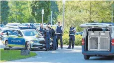  ?? FOTO: BERND WEISSBROD/DPA ?? Polizisten besprechen sich vor der Klinik am Weissenhof im Kreis Heilbronn. Vier Männer sind aus einer geschlosse­nen Station geflüchtet.