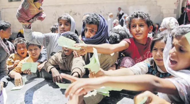  ??  ?? Yemenis present documents to receive food rations provided by a local charity, in Sana’a, Yemen, Apr. 13, 2017.