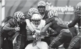  ?? Joe Murphy / Getty Images ?? UH tight end Romello Brooker, center, gets brought down by a host of Memphis defenders after making a first-half catch.