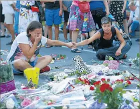  ?? FRANCOIS MORI/AP ?? Along Nice’s Promenade des Anglais on Saturday people pay respects to the victims of Thursday’s deadly truck attack with tears and tributes.