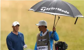  ?? ?? Rory McIlroy and his caddie Harry Diamond shelter from the rain on day two of the Scottish Open with worse weather forecast for the weekend. Photograph: Andrew Redington/ Getty Images