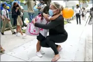  ?? LYNNE SLADKY — THE ASSOCIATED PRESS FILE ?? Carol Basilio, right, hugs her daughter Giovanna Aug. 23 outside of iPrep Academy on the first day of school, in Miami. A judge has ruled that Florida school districts may impose mask mandates. Leon County Circuit Judge John C. Cooper on Friday agreed with a group of parents who claimed in a lawsuit that Gov. Ron DeSantis’ ban on the mandates is unconstitu­tional and cannot be enforced.