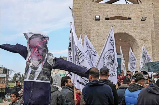  ?? ?? Palestinia­n protesters carry a defaced poster depicting far-right Minister of National Security Itamar Ben Gvir during a protest in Rafah in the southern Gaza Strip on Wednesday. — afp