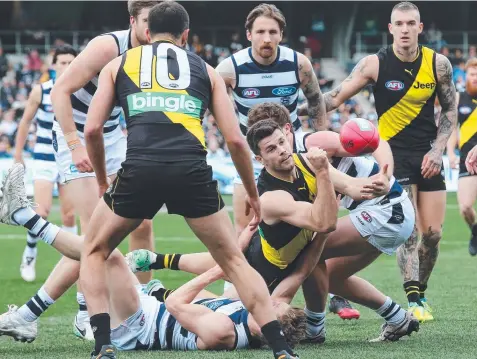  ?? Picture: MICHAEL KLEIN ?? CROWDED HOUSE: Richmond's Trent Cotchin fires out a handball amid congestion against the Cats.