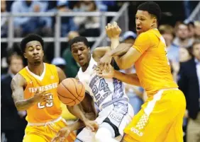  ?? THE ASSOCIATED PRESS ?? Tennessee’s Jordan Bowden, left, and Grant Williams get tangled up with North Carolina’s Kenny Williams during their game in Chapel Hill last December. The Vols begin play in their summer league Monday and will play three games during a trip to Europe...