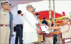  ?? MANOJ DHAKA/HT ?? Haryana chief minister Manohar Lal Khattar honouring a cadet after passingout parade at the Police Training Centre at Sunariya in Rohtak on Friday.