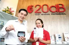  ??  ?? Mok (left) and staffer Fion Wee show some of 20dB’s products and brochures at the Simpang Tiga premises in Kuching.