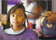  ??  ?? KOURTNEY LYLES, 12, of Granada Hills has her hair braided by stylist Lashawnna Courtney at Kim’s Touch of Class.