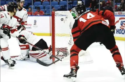  ?? NATHAN DENETTE, THE CANADIAN PRESS ?? Maxime Comtois puts the puck in the Swiss net for Canada’s eighth goal of the night, with less than a minute left to go in the third period.
