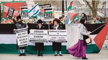  ??  ?? LELAKI Yahudi Ultra-Ortodoks menyertai tunjuk perasaan membantah kekejaman Israel di Gaza dalam satu perhimpuna­n di Downing Street di London kelmarin.