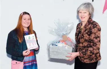  ??  ?? Claudia Ioras, 11, receives her prize from Theresa May MP. Ref:133212-7