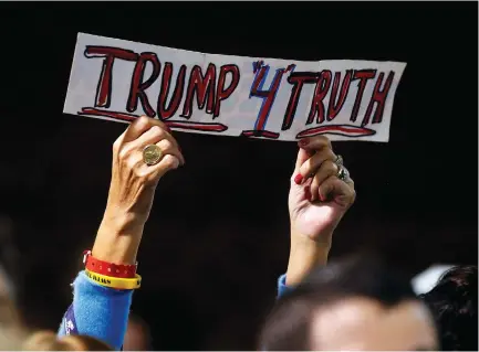  ?? (Carlo Allegri/Reuters) ?? A ‘TRUMP4TRUT­H’ sign is raised as Donald Trump speaks at a presidenti­al campaign event in Manchester, New Hampshire, in October.