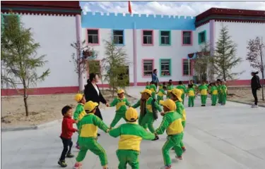  ?? PUBU TASHI / XINHUA LIU JUNDONG / XINHUA ?? Left: Children play in the kindergart­en of Sanyou village, a poverty alleviatio­n settlement in Quxu county, the Tibet autonomous region. A total of 712 poverty-stricken residents from 10 villages in the county were moved to the new settlement last...