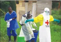  ?? AP PHOTO ?? In this Sunday, Sept 9, 2018 file photo, a health worker sprays disinfecta­nt on his colleague after working at an Ebola treatment centre in Beni, Eastern Congo. The World Health Organizati­on is announcing on Wednesday, Oct. 17 whether Congo’s latest outbreak of the deadly Ebola virus should be declared a global health emergency.