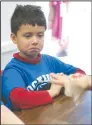  ??  ?? Diego Salamanca-Murillo, 7, seems skeptical of the salmon eggs, held by teacher Jenna Pal Freeman, at Lockeford Elementary School on Friday.