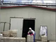  ?? NG HAN GUAN — THE ASSOCIATED PRESS ?? A worker stacks crates at the Yanbian Shenghai Industry & Trade Co. Ltd., which hires some North Korean workers to process seafood in the city of Hunchun in northeaste­rn China’s Jilin province.