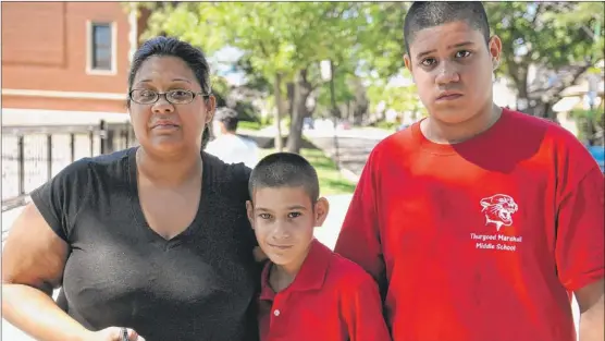  ??  ?? Jasmine Rivera and her sons, Isaiah and Israel Lebron, both 13, outside Reinberg Elementary on the Northwest Side. | AL PODGORSKI~SUN-TIMES