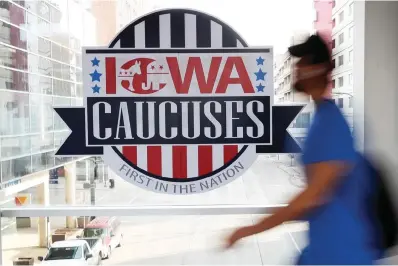  ?? The Associated Press ?? ■ A pedestrian walks past a sign for the Iowa Caucuses on a downtown skywalk Feb. 4, 2020, in Des Moines, Iowa. Democrats are poised to strip Iowa of its traditiona­l lead-off spot in the presidenti­al nominating calendar in 2024, part of a broader effort to better reflect the party’s deeply diverse electorate by allowing less overwhelmi­ngly white states to vote first.