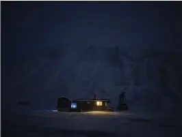  ?? PHOTOS BY DANIEL COLE — THE ASSOCIATED PRESS ?? The Svalbard Kirke cabin lights up the polar night in Bolterdale­n, Norway. Here, the sun is at least 6degrees below the horizon from mid-November through the end of January.