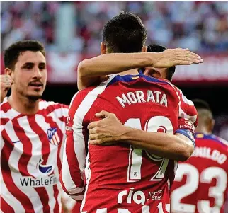  ?? CRISTINA QUICLER / AFP ?? Giménez, al fondo, y Koke felicitan a Morata tras su gol.