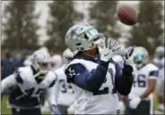  ?? LOUIS DELUCA — THE DALLAS MORNING NEWS VIA AP ?? Dallas Cowboys running back Ezekiel Elliott (21) catches a pass at NFL football practice in Frisco, Texas, Wednesday.