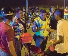  ??  ?? ANGGOTA polis memeriksa lesen penunggang motosikal.