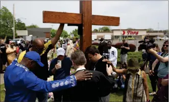  ?? THE ASSOCIATED PRESS ?? A group prays at the site of a memorial for the victims of the Buffalo supermarke­t shooting outside the Tops Friendly Market on Saturday, May 21, 2022, in Buffalo, N.Y.