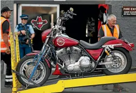  ?? GETTY IMAGES ?? Armed police stand guard as seized motorcycle­s are removed from a boxing gym run by the Head Hunters gang in Ellerslie, Auckland, in 2015.