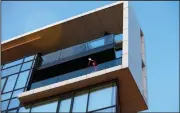  ?? (AP/Darko Vojinovic) ?? A woman bangs a pot with a spoon Monday on a balcony in Belgrade, Serbia. Activists have been holding protests from windows and balconies, banging on pots and blowing whistles in opposition to Serbia’s populist leadership.